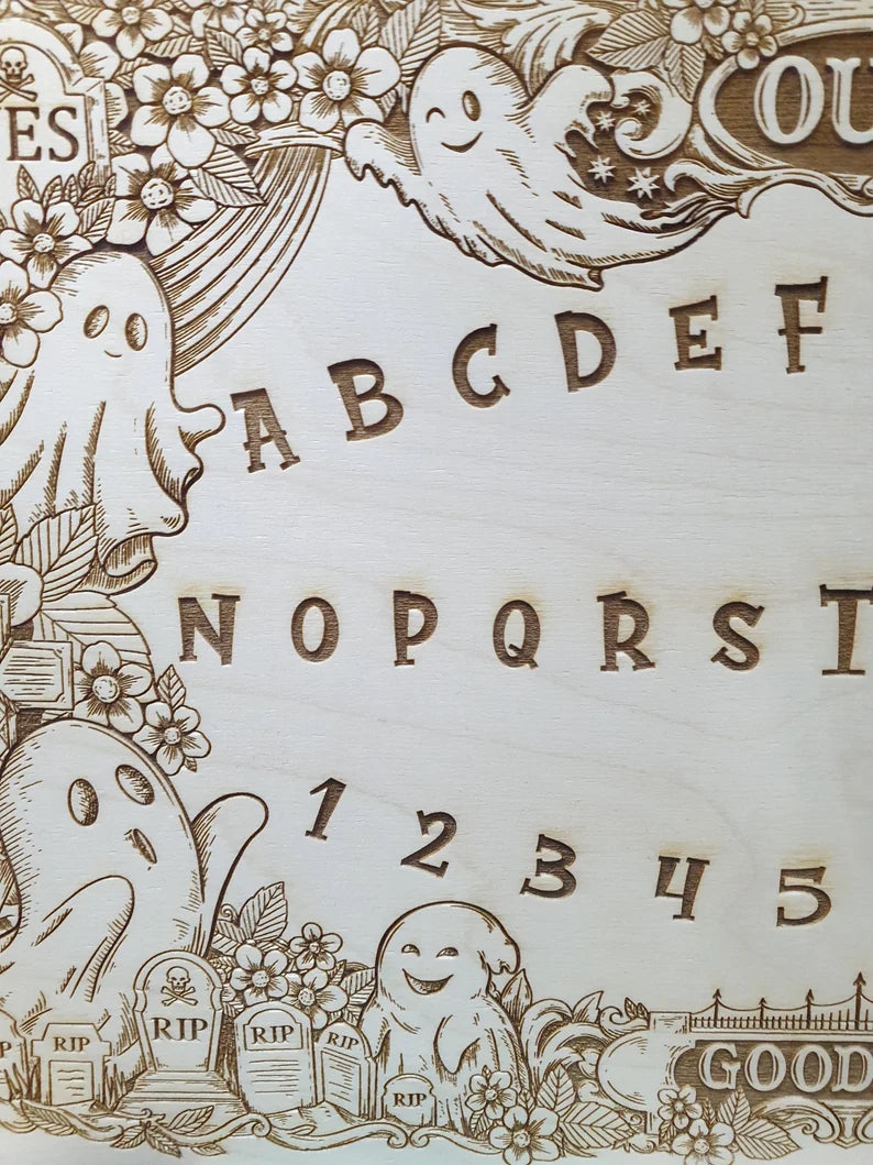Close up of cute ghost and flower engraving on wooden spirit talking board
