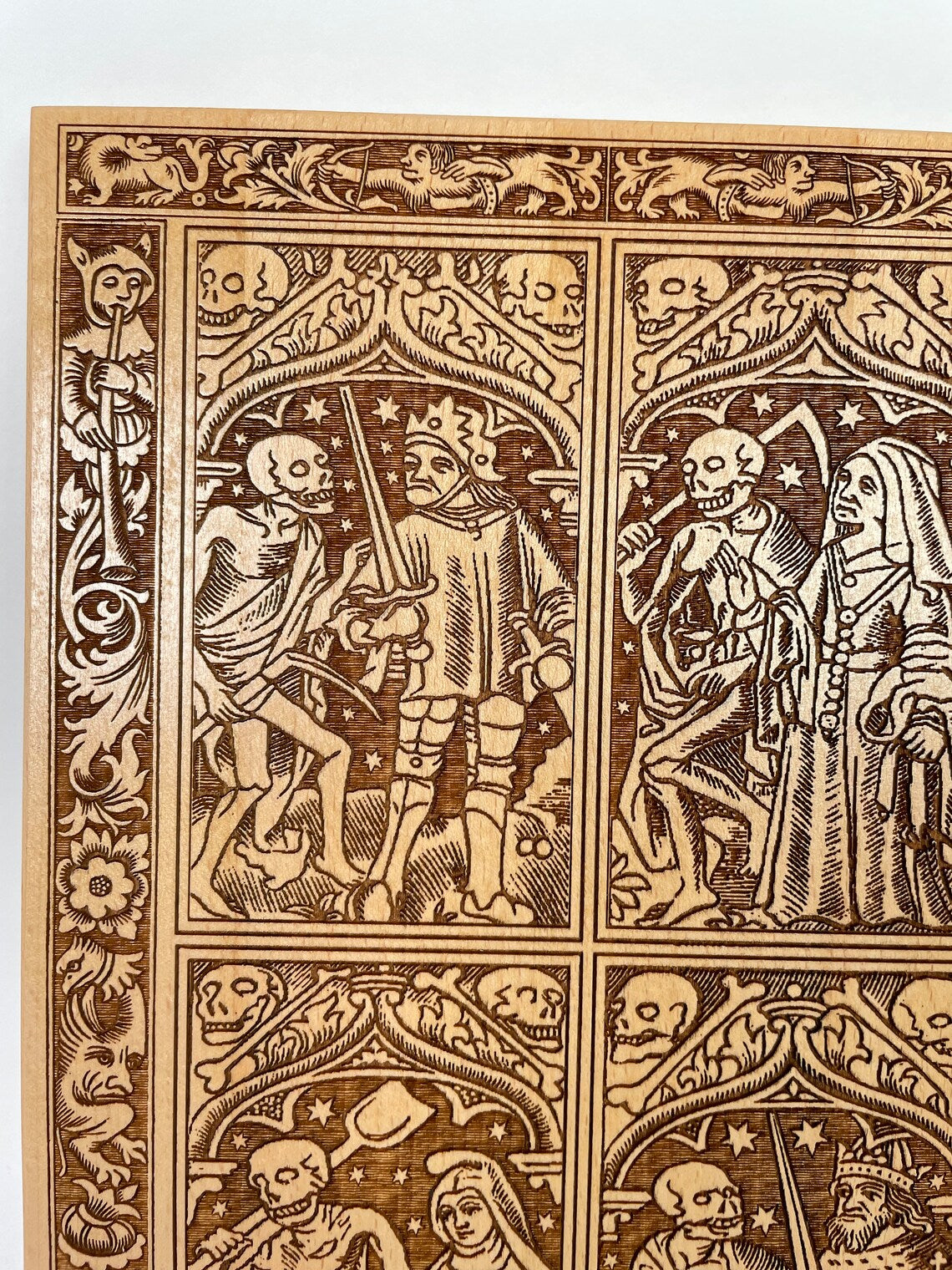 Close up of Danse Macabre woodcut style engraving on solid wood wall art
