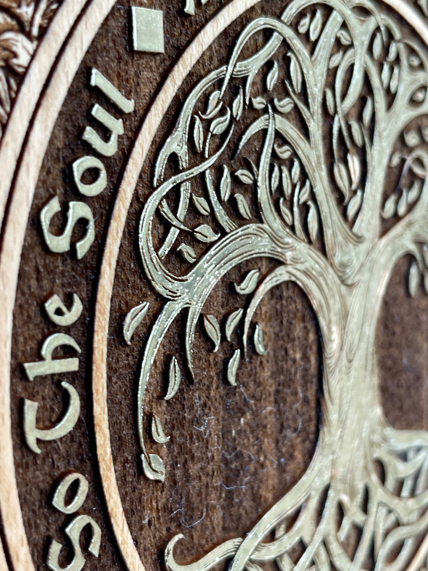 Close up of engraved Tree of Life and As Above So Below sacred design on wooden wall decor
