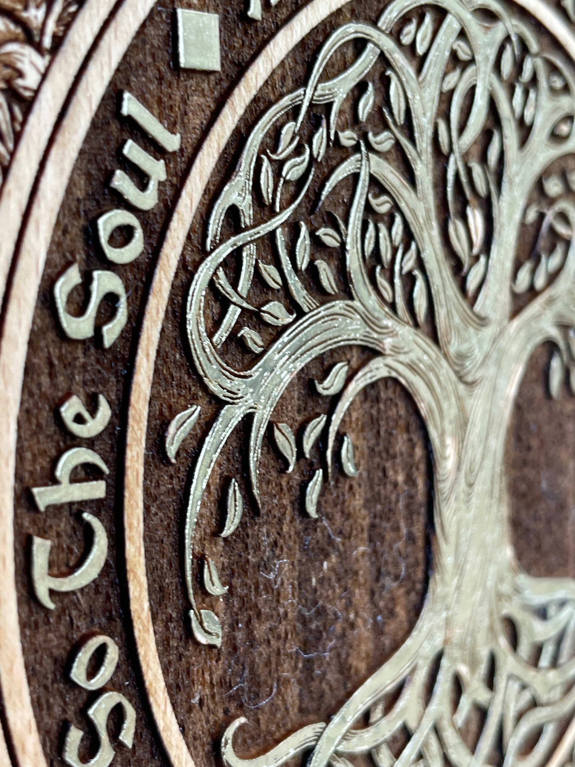 Close up of engraved Tree of Life and As Above So Below sacred design on wooden wall decor
