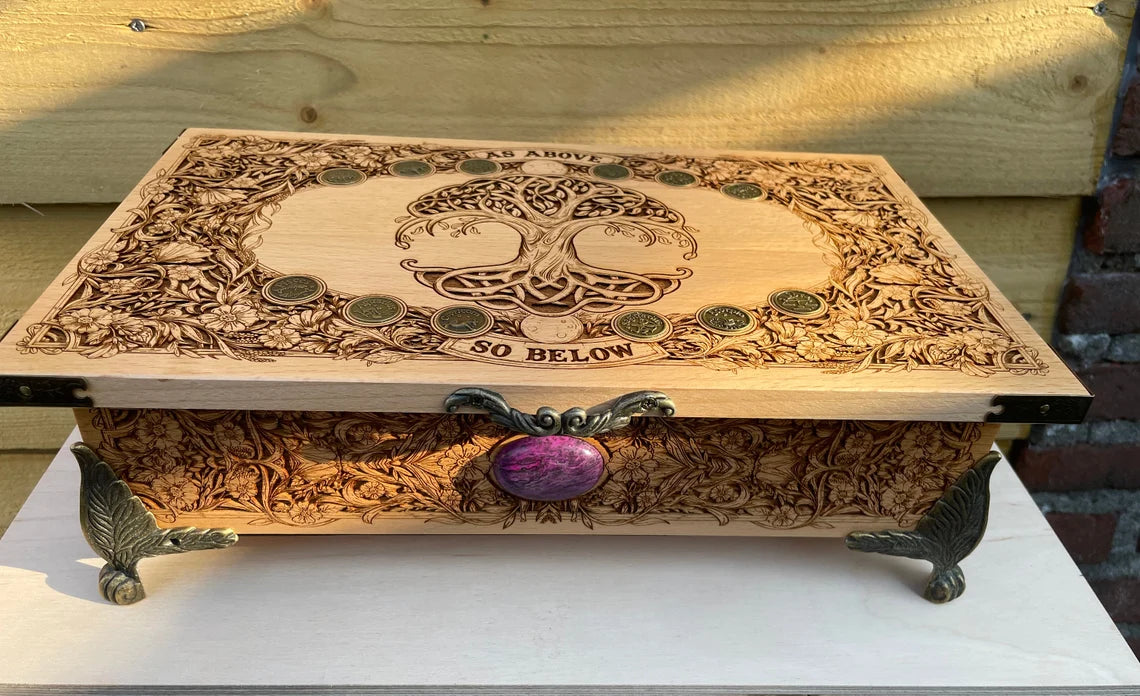 Large wooden altar chest open with tarot decks and crystals inside
