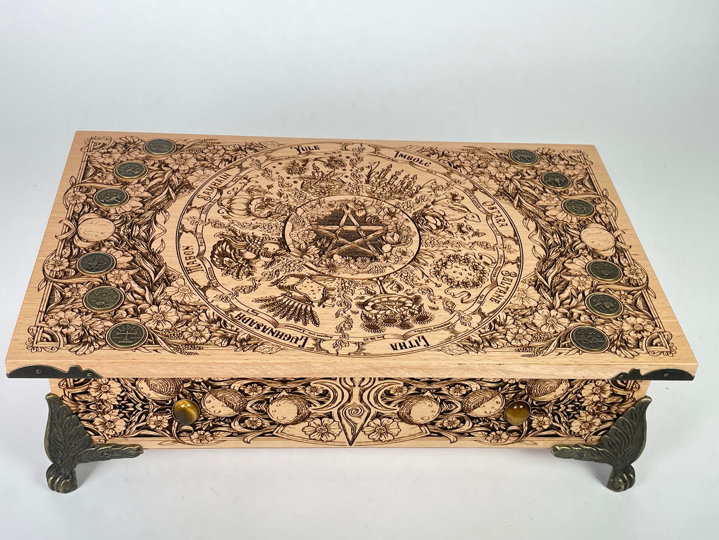 Close up of Wheel of the Year sabbat engraving on wooden altar table
