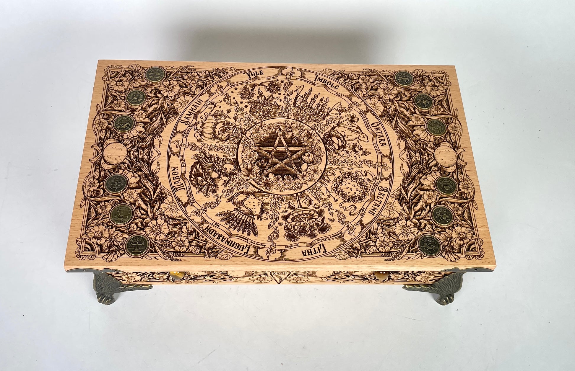 Close up of Wheel of the Year sabbat engraving on wooden altar table
