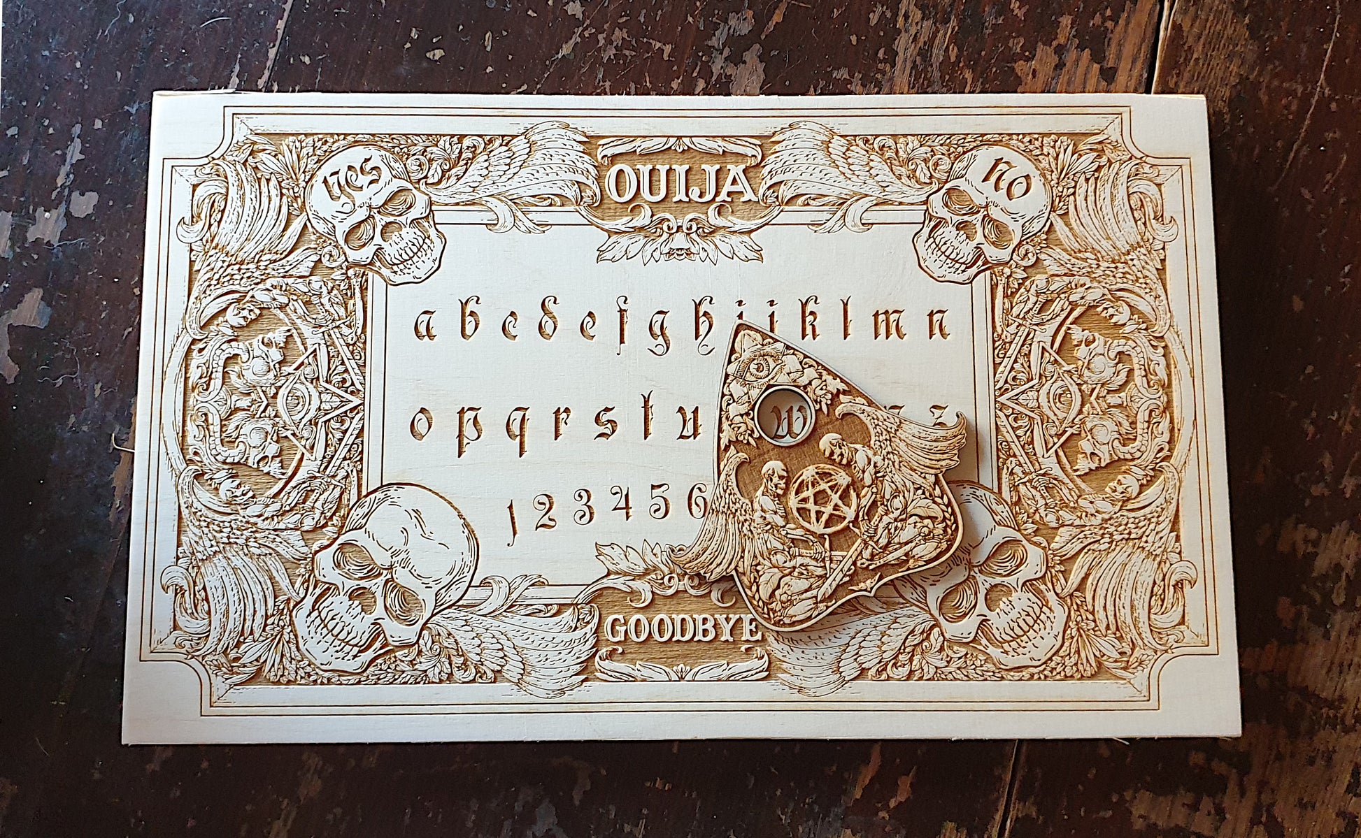 Ouija board with demons and skulls wooden engraving, wood gothic skull spirit board. 